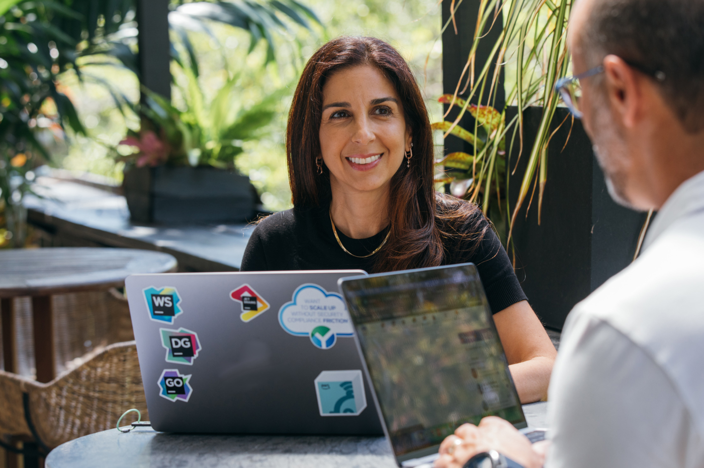 A man and a woman are busy in conversation with a laptop in front of them.